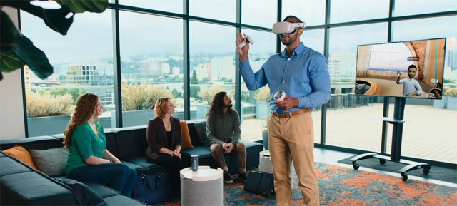 Hybride Designprüfung mit Autodesk Workshop XR: Ein Nutzer mit VR-Brille interagiert im virtuellen Raum, während das Team auf dem Bildschirm folgt