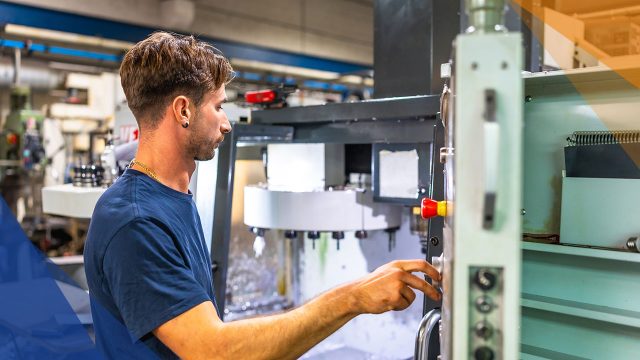 Mann an Fräsmaschine beim Rüsten - CAM